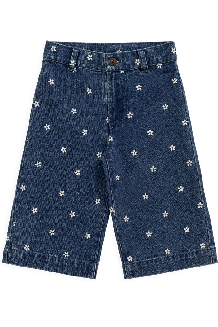Blue denim  pants with white floral patterns on a white background