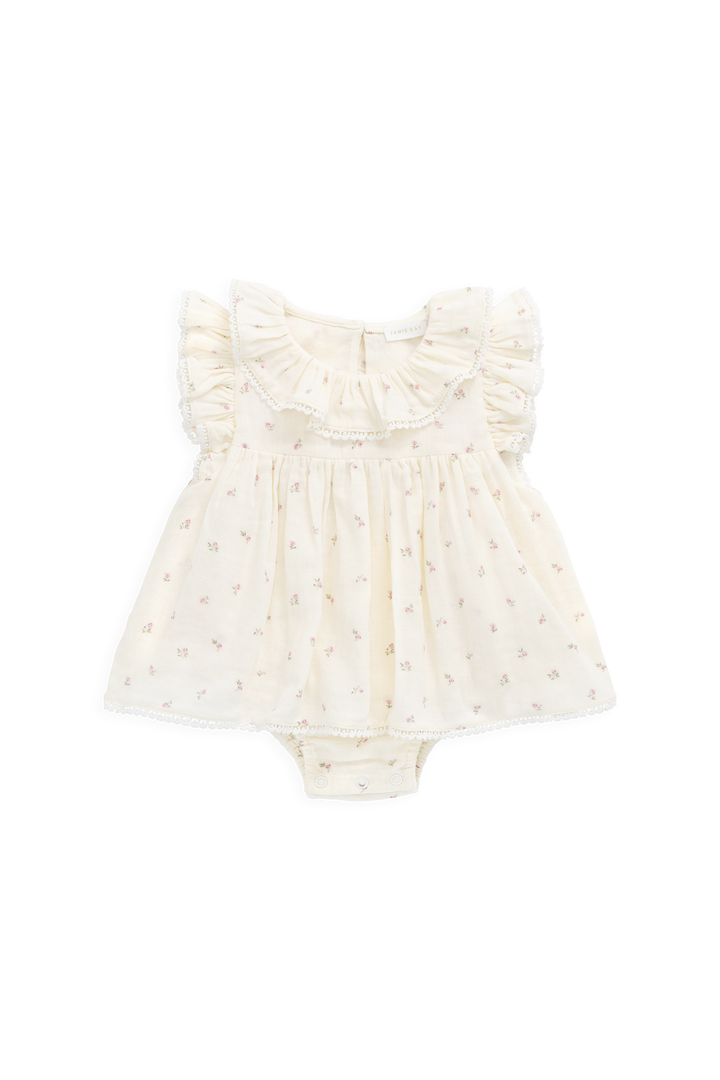 White baby romper with ruffled details on a white background