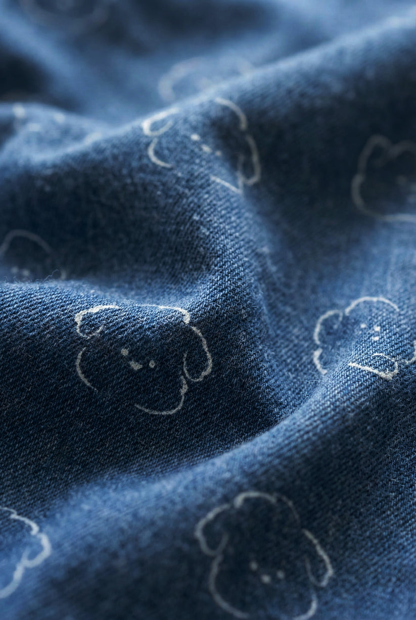 Close-up of blue fabric with embroidered dog shapes