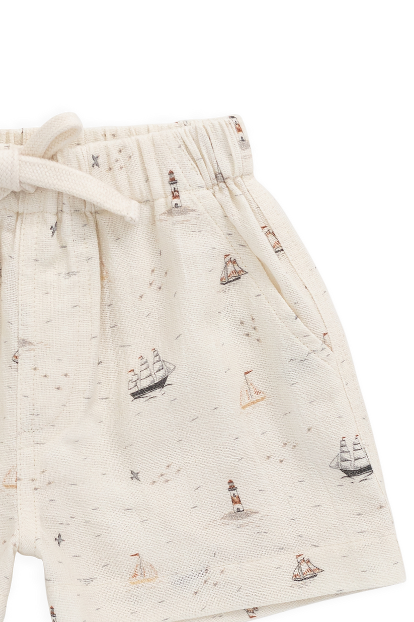 Beige shorts with sailboat pattern on a white background