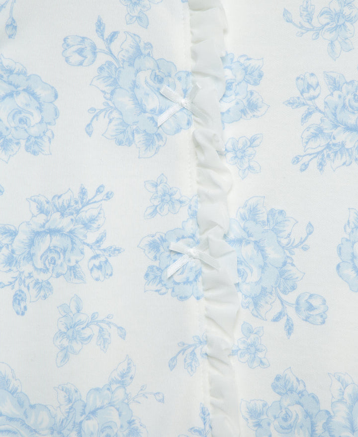 White fabric with blue floral pattern and ruffled edge