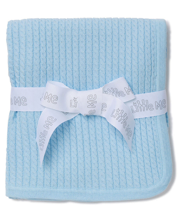 blue cable knit baby blanket tied with a white ribbon