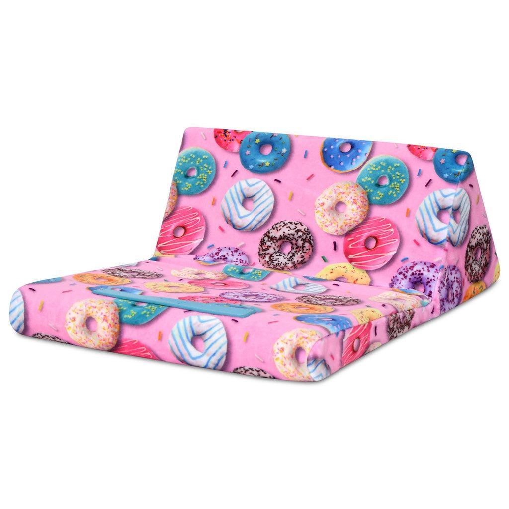 tablet pillow with donut all over print. pink background with multi color donuts . this picture shows the table pillow has a place to lean the tablet or book while the pillow folds out. 