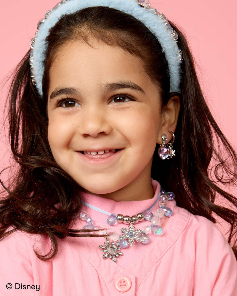 little girl modeling the elsa headband and a necklace using the beads from the kit. 