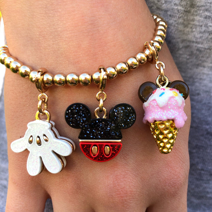 Bracelet with Mickey Mouse and ice cream cone charms on a wrist.
