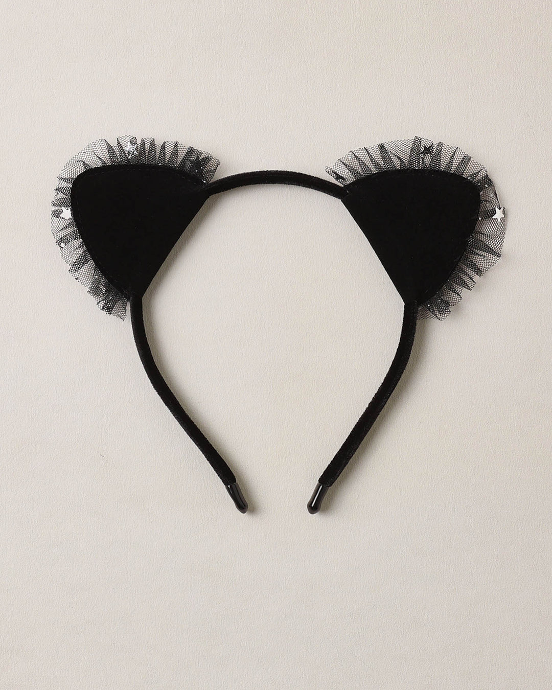 Black cat ear headband with tulle on a beige background