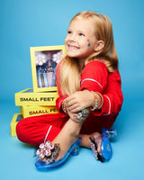 little girl posing near the shoes and wearing a pair so excited to be so fancy!