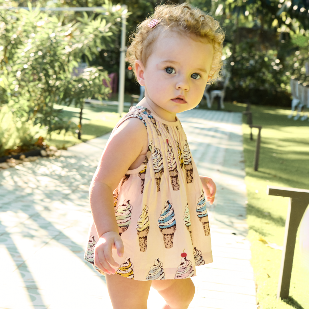 Young child wearing an outfut with ice cream cone pattern outdoors