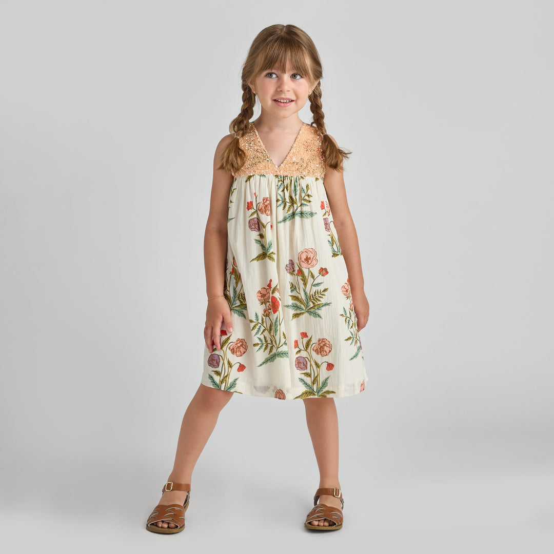 Young girl wearing a floral dress on a plain background