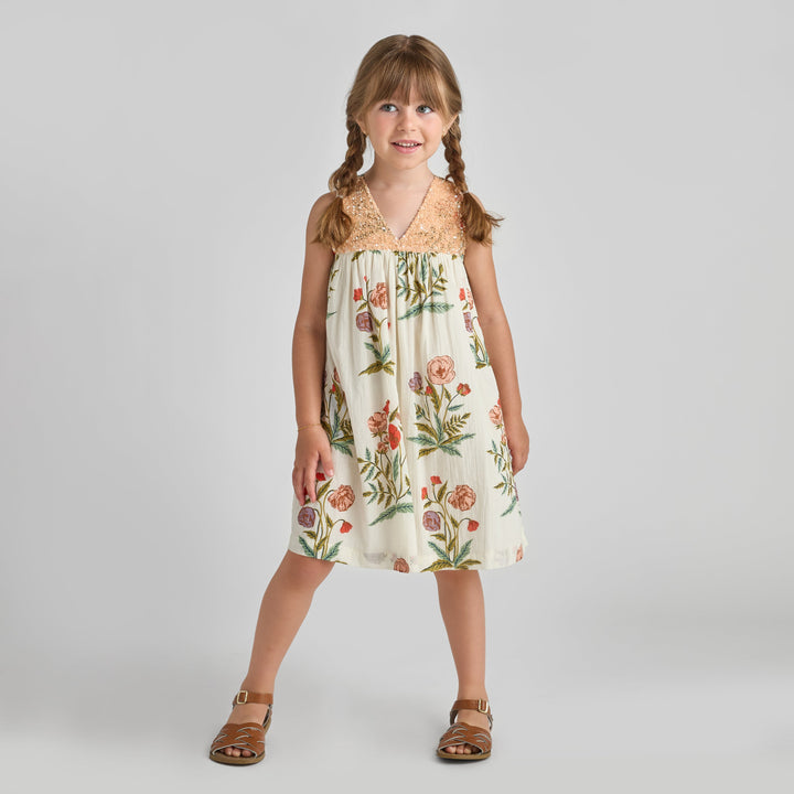 Young girl wearing a floral dress on a plain background
