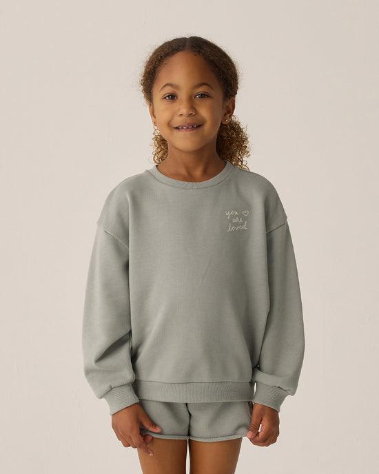 little girl wearing a long sleeve sweatshirt and matching shorts in a eucalyptus color. 