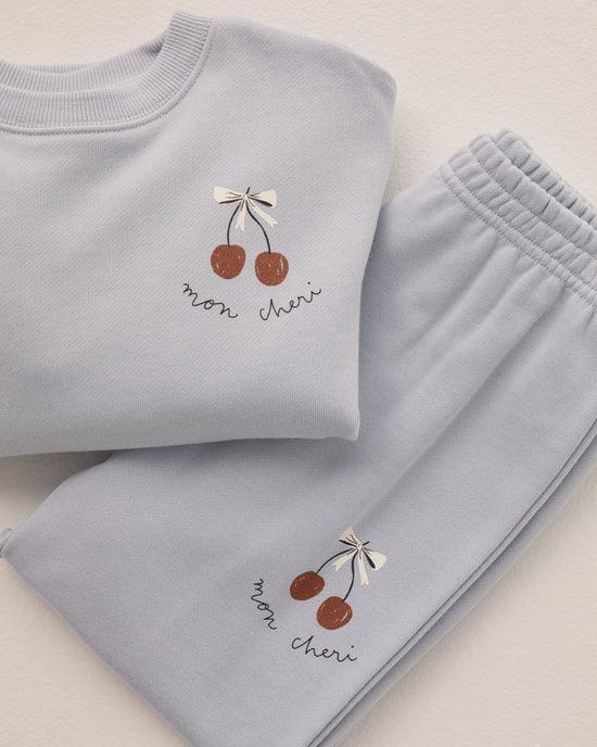 picture of sweatshirt and matching sweatpant, both with the same cherry graphic. this shows you a close up of the cherries and the words "mon cheri"