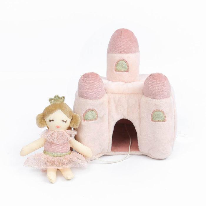 plush princess castle in the color pink. Castle is light with darker pink tops. Princess is tethered to the castle with a piece of string