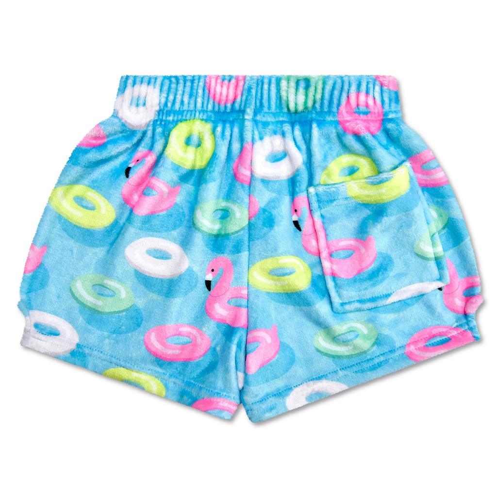 elastic waist plush shorts in a bright blue with multi color pool floats all over the shorts. one of the floats being a flamingo. pocket in the back. 