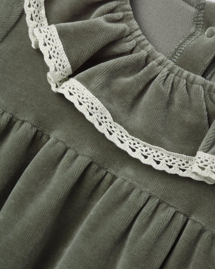 Close-up of a dark olive green dress or nightgown with a gathered neckline and white crochet lace trim.