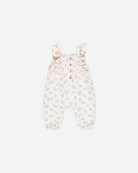 beige romper with ruffle at the sleeves with tiny strawberries on it. 