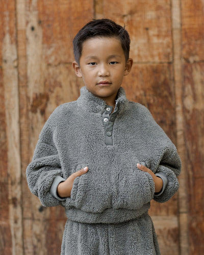 boy modeling the forest green fleece 3/4 mock neck with snaps.