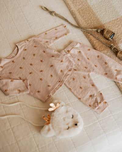 close up picture of the print on the 2 piece set, dusty rose set with gingerbread people all over it. 