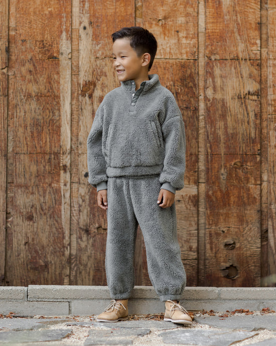 boy modeling the forest green fleece 3/4 button down with hidden pockets. 