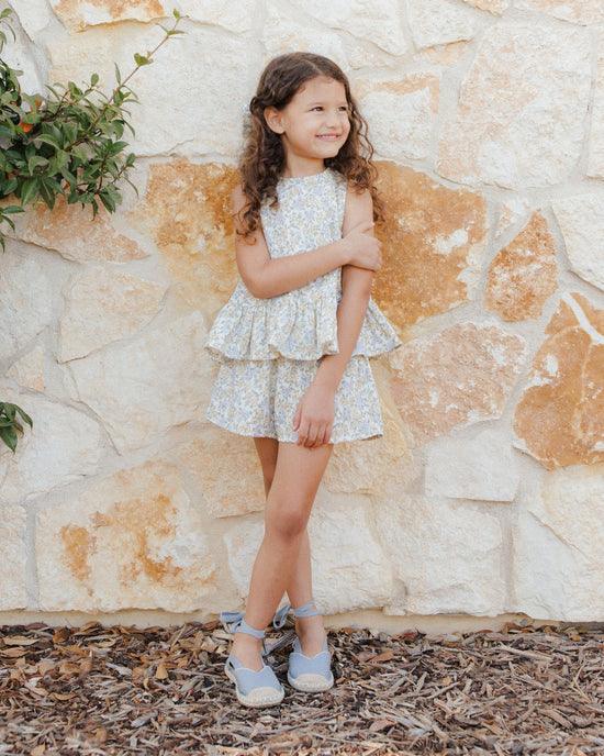 young girl modeling the outfit, this picture shows how flattering the bottom of the top is and just where the ruffle hits at the waist. 