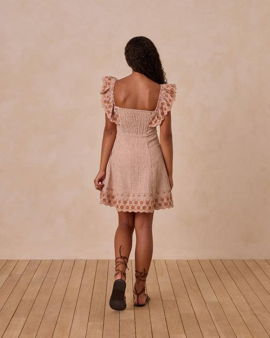a look at the back of the dress with ruffle at the sleeve and at the bottom of the dress, eyelet detail on the ruffle. smocking on the back. 