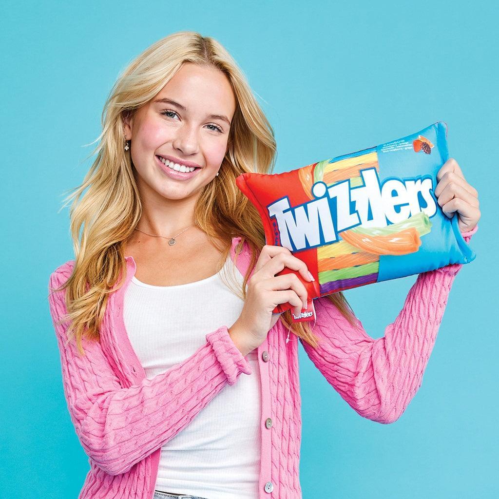 girl holding up the rainbow twizzler microbead pillow. 