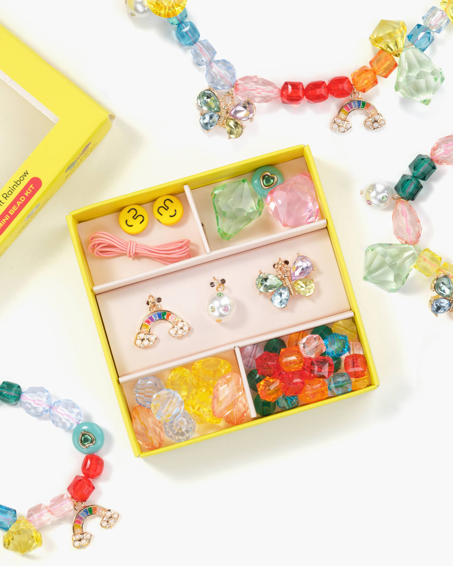 Colorful jewelry set with earrings and necklaces in a yellow box on a white background