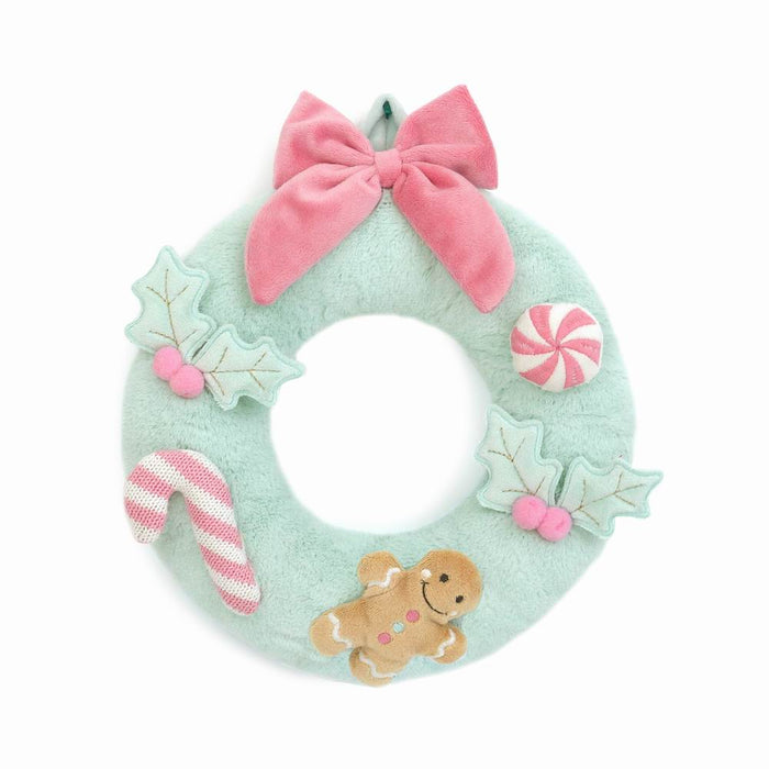 mint green plush wreath with pink bow and gingerbread cookie at the bottom with candy cane and mint attached to the wreath