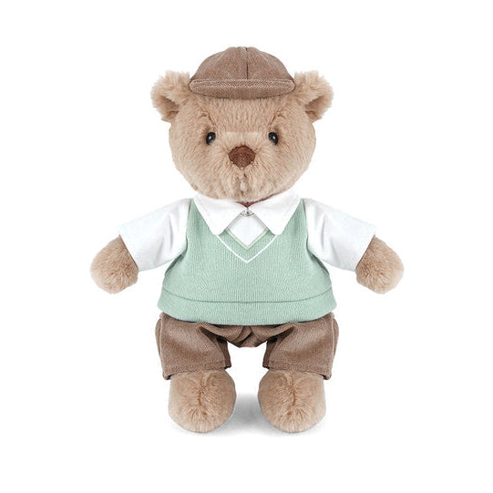 Stuffed teddy bear wearing a suit and hat on a white background