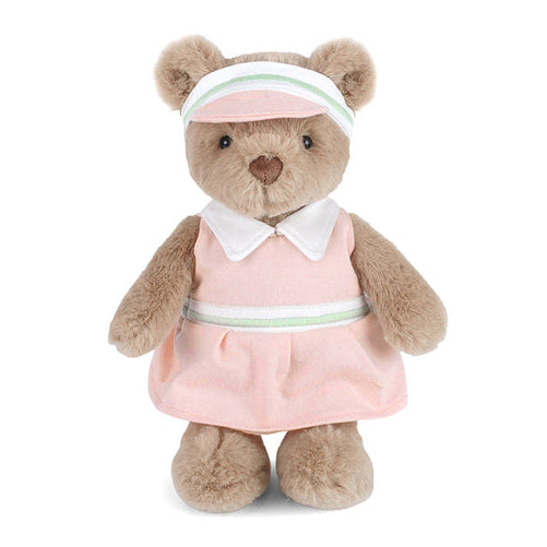 Stuffed teddy bear wearing a pink golf dress and headband on a white background