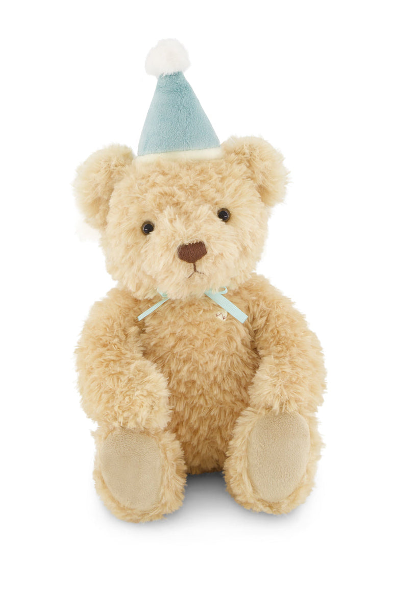 Teddy bear wearing a blue party hat on a white background