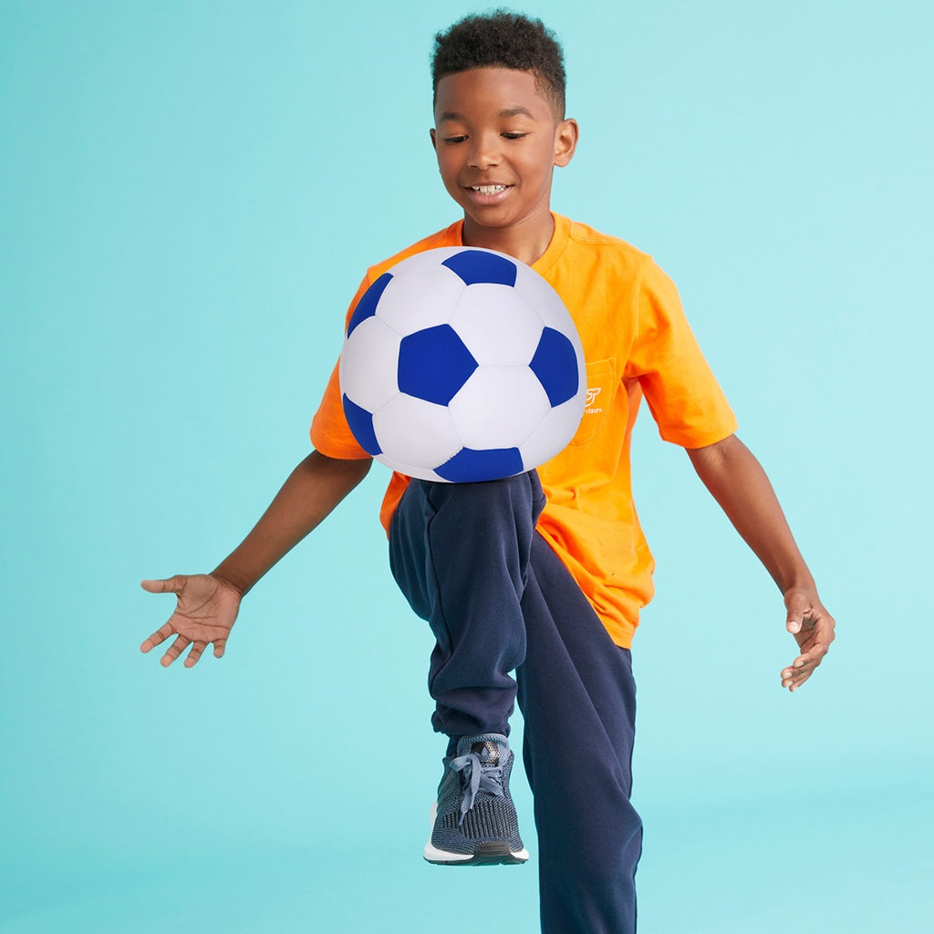 Child holding a blue and white soccer ball against a light blue background