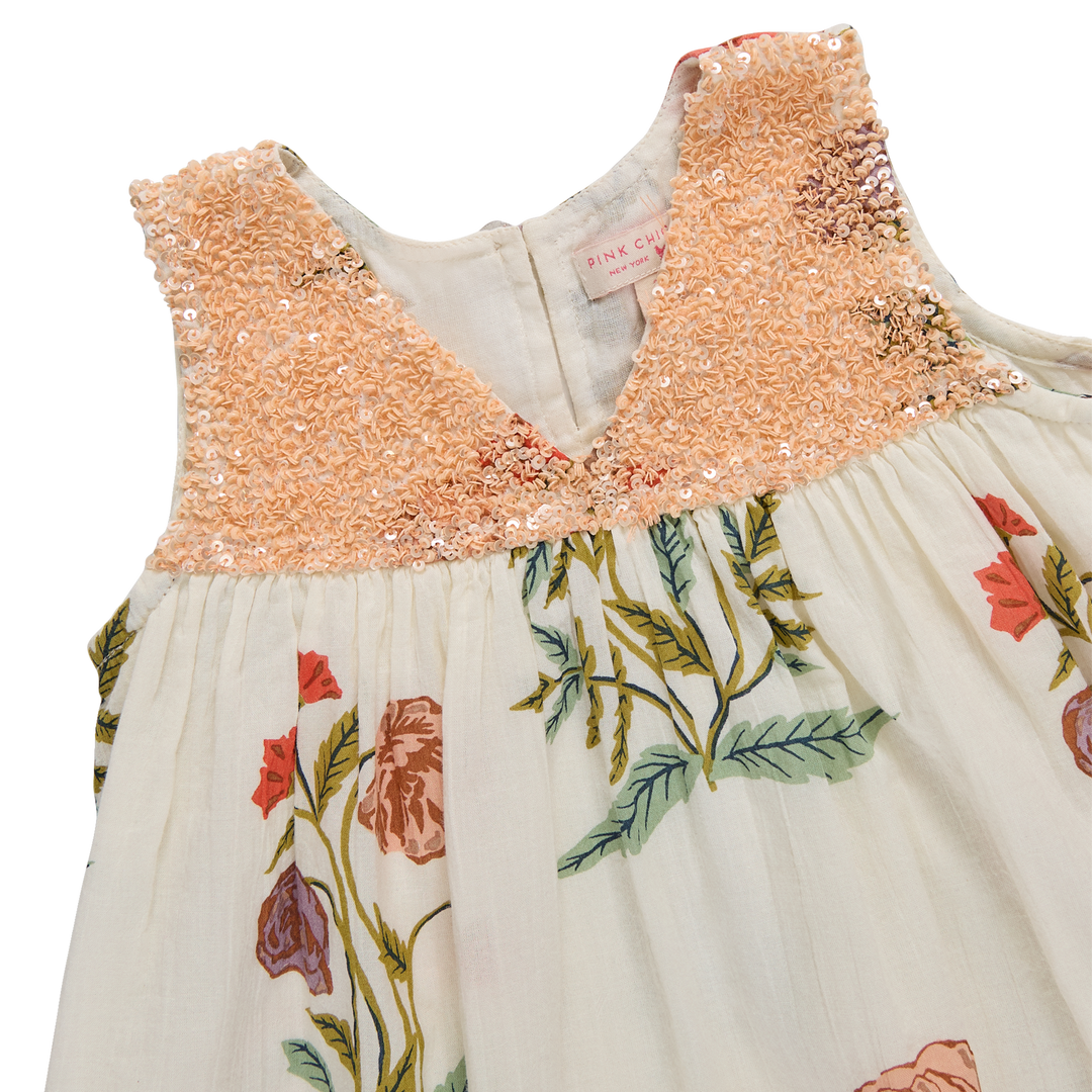 Children's dress with sequined top and floral skirt on a white background