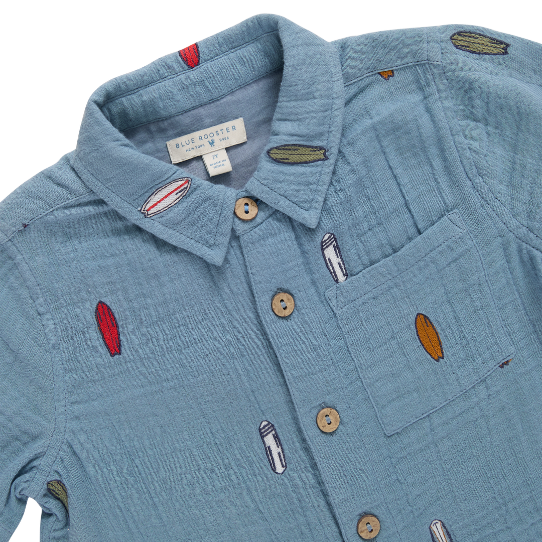 Blue shirt with embroidered designs on a white background