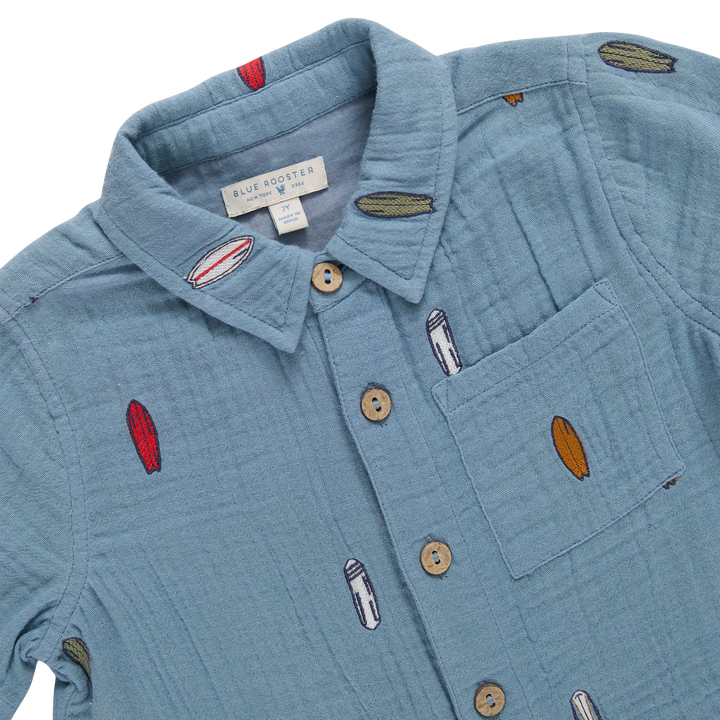 Blue shirt with embroidered designs on a white background