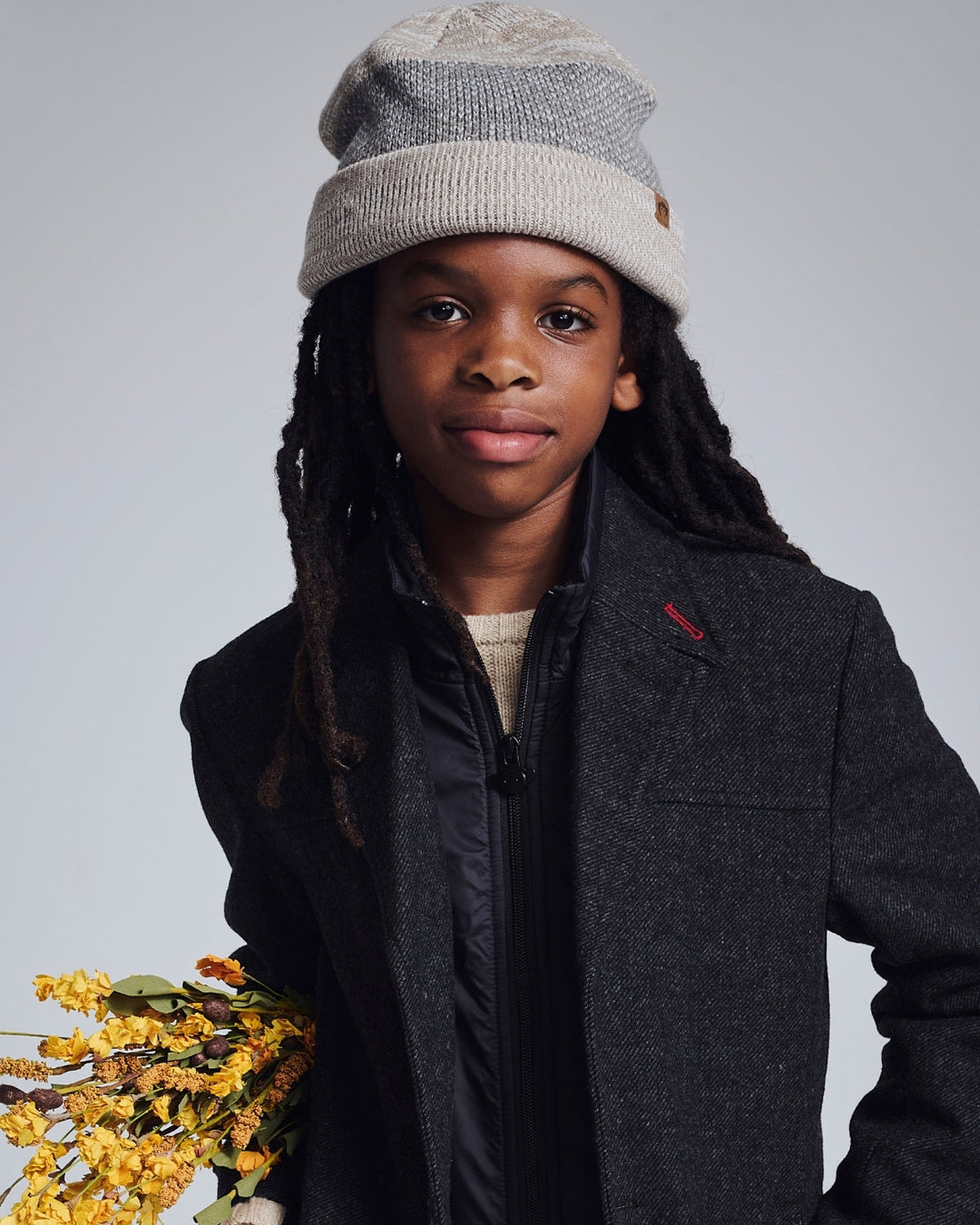 young boy wearing a knit beanie hat and an overcoat 