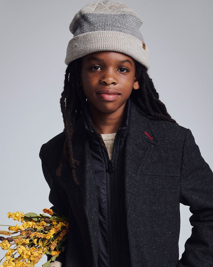 young boy wearing a knit beanie hat and an overcoat 