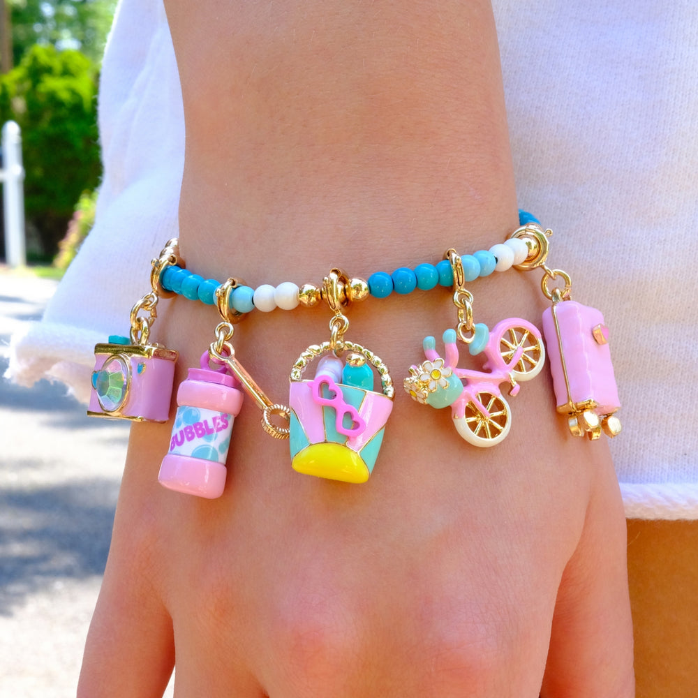 Colorful charm bracelet on a person's wrist with various charms.