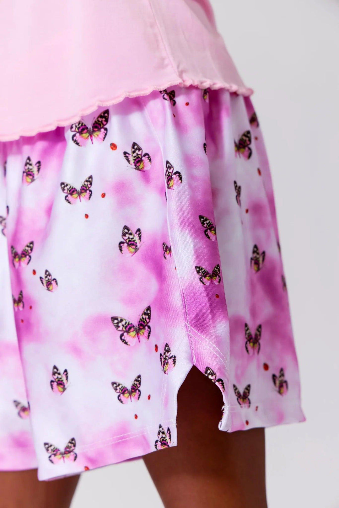 close up of shorts that are a purple swirl color with butterflies all over them. 