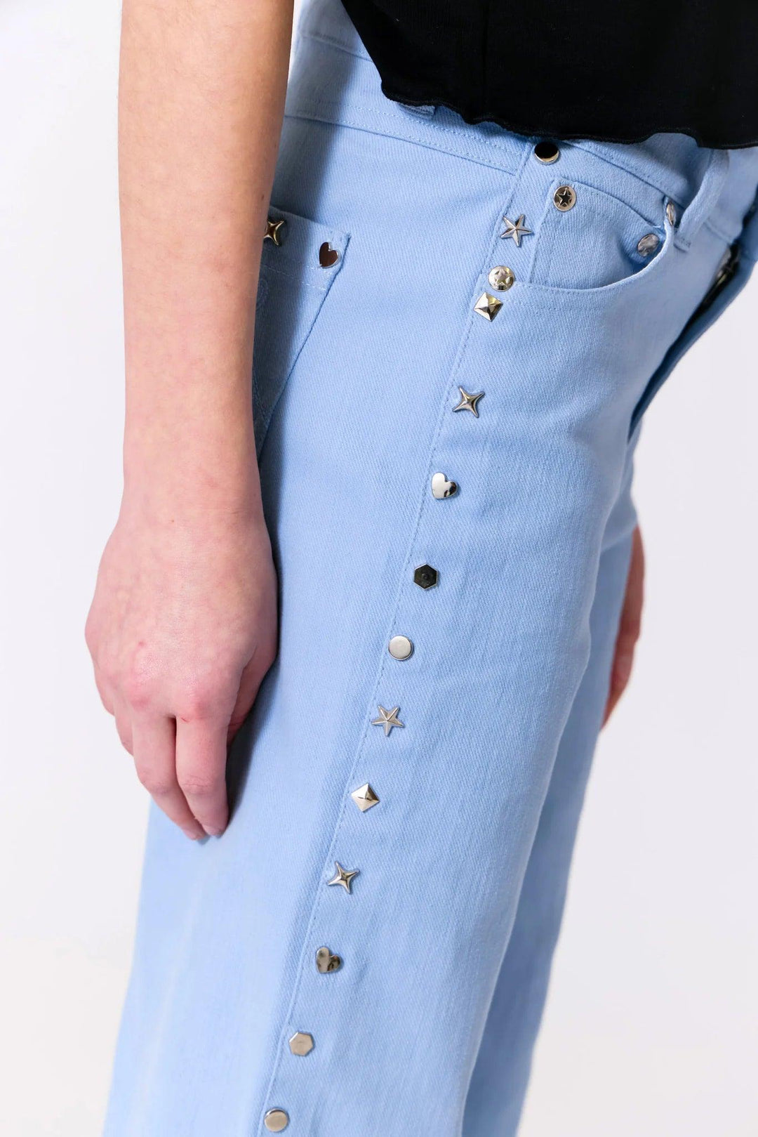 sideview of the blue wideleg, loose fit twill pants with studs going down the center. 