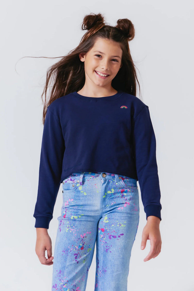 Girl wearing Terez Raw Hem Cropped Crew Top in Navy with splattered paint denim pant