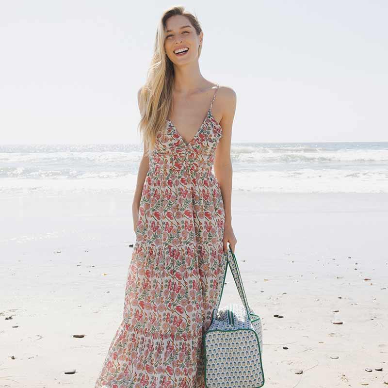 woman modeling the butterfly vines dress while standing on the beach 