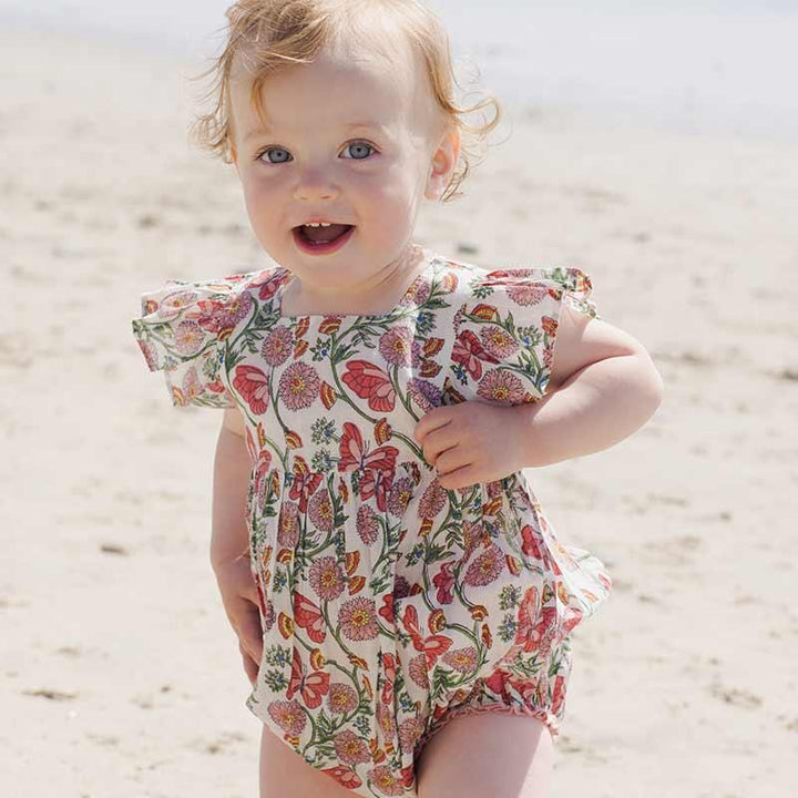 baby modeling the butterfly vines bubble with ruffles at the shoulder and snaps at the bottom of the bubble. 