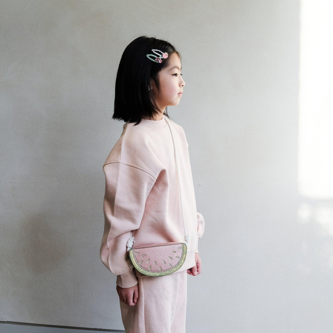 little girl modeling the watermelon bag and hitting at the waist. 