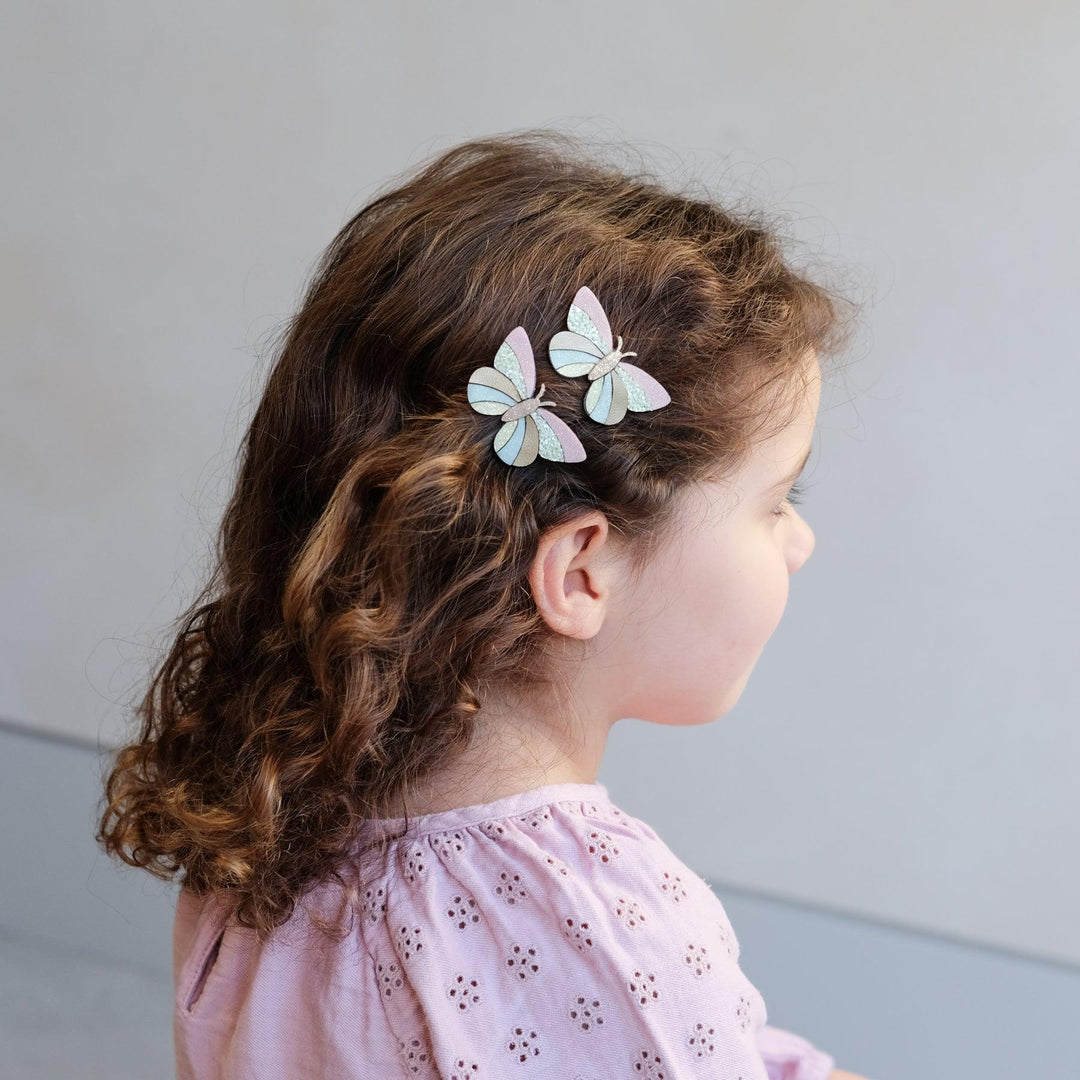 little girl with 2 butterfly hair clips in her hair. 