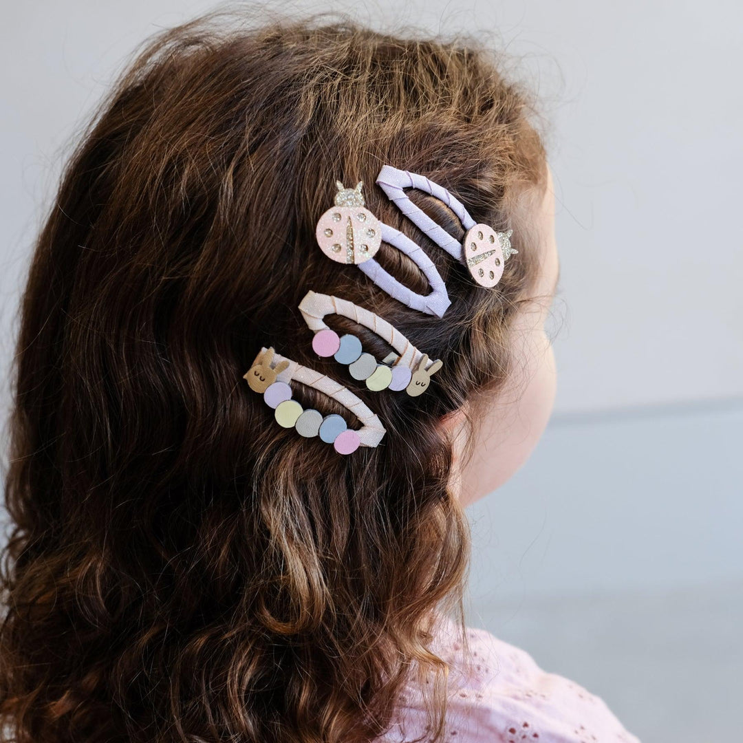 set of 4 hair clips in the little girl's hair: lady bugs and caterpillars. 