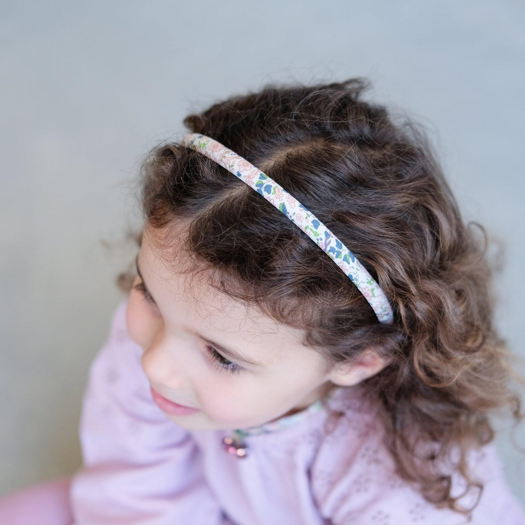 picture of little girl wearing the thin floral headband. 