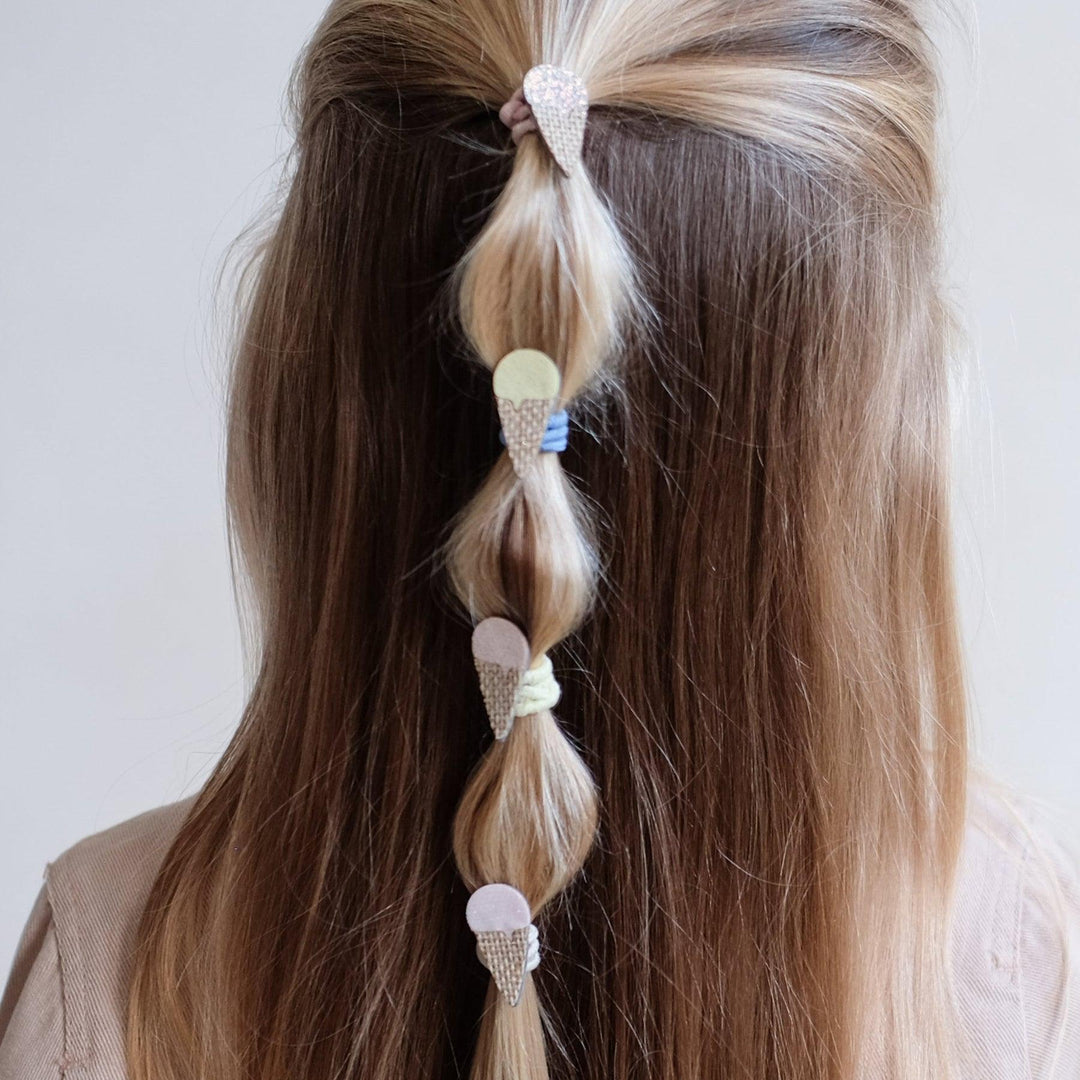 ice cream cones attached to ponytail holders in a little girl's hair. 
