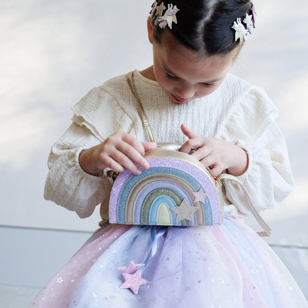 little girl peering inside the rainbow handbag 