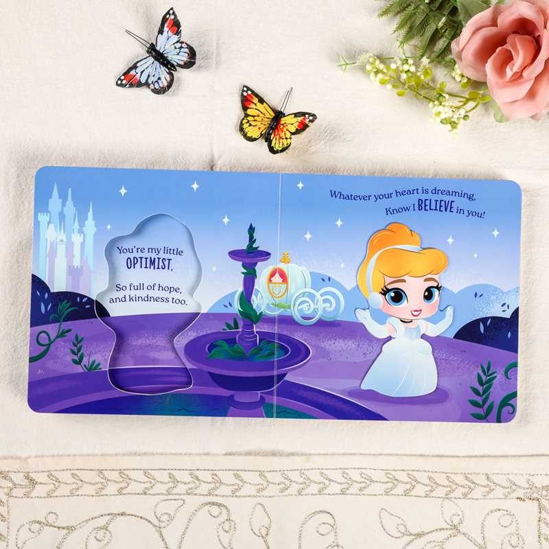 Children's book with a princess character and motivational quote on a decorative surface with butterflies and flowers.